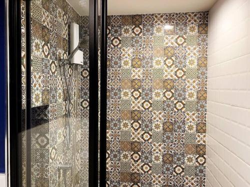 a shower with a glass door with a tiled wall at Phuket Town - Central Luxury in Phuket Town