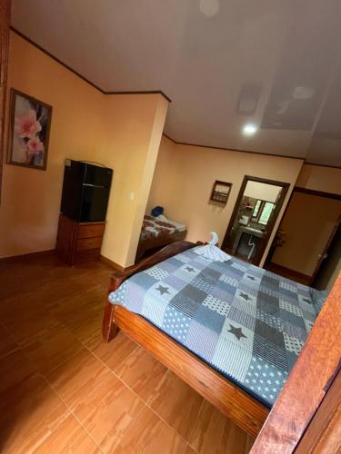 a bedroom with a bed and a flat screen tv at Ceiba lodge in Drake