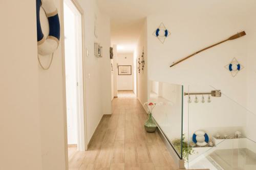 un pasillo de una casa con paredes blancas y suelo de madera en estea, en Castellaneta Marina