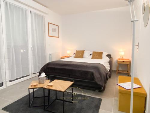 a bedroom with a large bed and a table at Le Jardin Rambolitain - Terrasse et Parking in Rambouillet