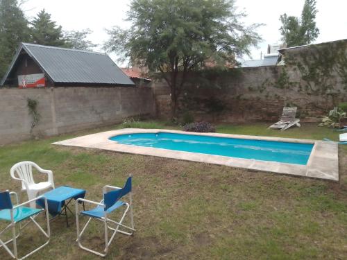 a yard with chairs and a swimming pool at Casa c/pileta Cosquin in Cosquín