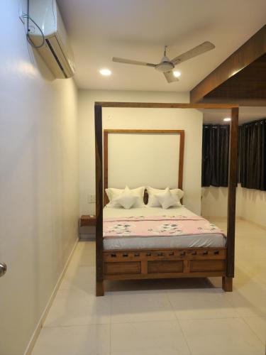 a bedroom with a bed and a tv on the wall at Kuber hotel in Valsad