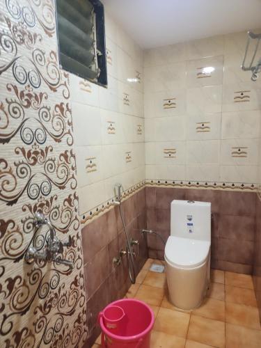 a bathroom with a toilet and a shower at Kuber hotel in Valsad
