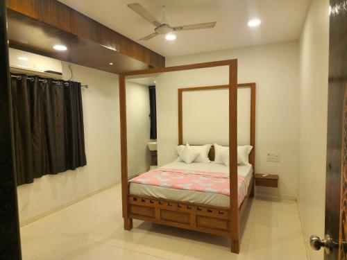 a bedroom with a canopy bed with a mirror at Kuber hotel in Valsad