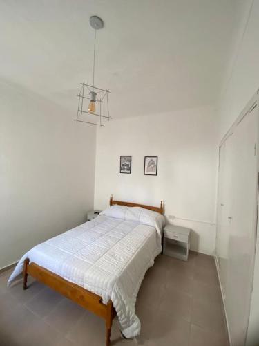 ein Schlafzimmer mit einem Bett in einem weißen Zimmer in der Unterkunft Casa a 400 M de la playa in Mar del Plata