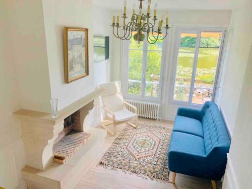 uma sala de estar com um sofá azul e um lustre em Maison de charme avec vue sur château em Pierrefonds