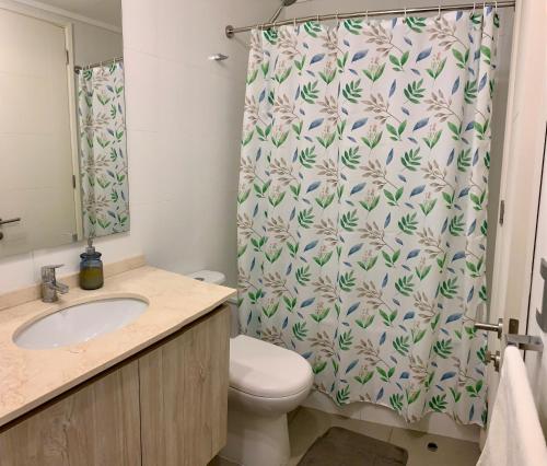 a bathroom with a toilet and a shower curtain at Departamento nuevo, vista al Mar, Reloj de Flores in Viña del Mar