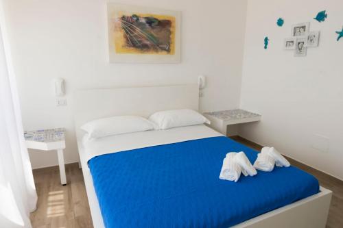 1 dormitorio con 1 cama con sábanas azules y almohadas blancas en estea, en Castellaneta Marina