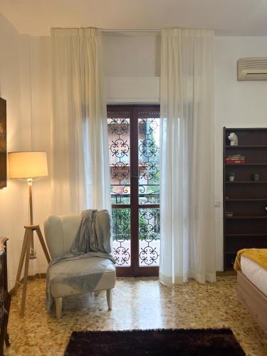 a bedroom with a bed and a chair and a window at Gelsi Apartment - Roma Metro C in Rome