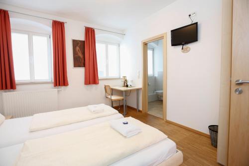 a hotel room with two beds and a television at Altstadtpension Friedberg in Friedberg