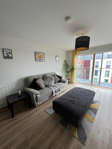 a living room with a couch and a large window at Belfast Luxury Apartment in Belfast