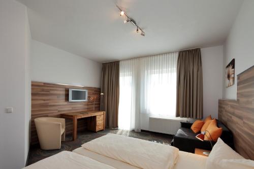 エッセンにあるPetul Apart Hotel Residenzのベッドと机があるホテルの部屋