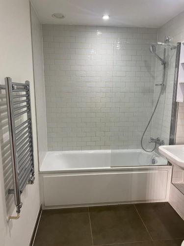 y baño con bañera blanca y lavamanos. en JJ Luxury Apartment, en Londres