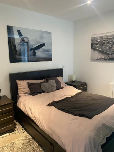 1 cama en un dormitorio con una foto en la pared en JJ Luxury Apartment, en Londres