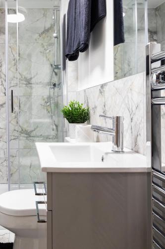 a bathroom with a sink and a toilet and a shower at Popular Two Bed Apt in Leeds City in Headingley