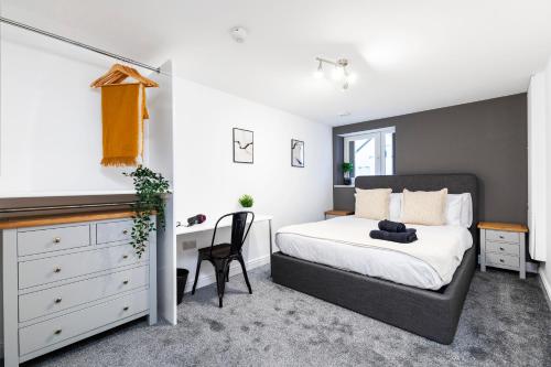 a bedroom with a bed and a desk at Luxury Two Bed Apartment with 55in TVs and Netflix in Headingley