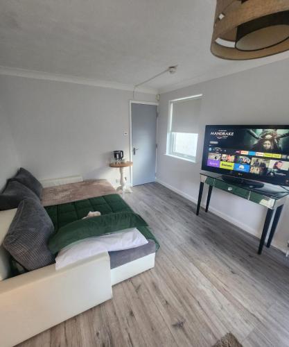 a bedroom with a bed and a flat screen tv at Alexandra Palace Sleep Overs in London