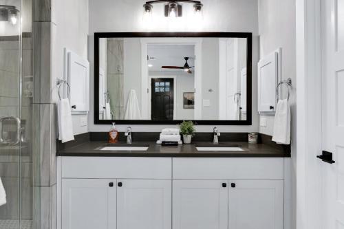 a bathroom with two sinks and a large mirror at Evergreen - A Birdy Vacation Rental in San Antonio