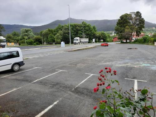 an empty parking lot with a white van parked in it at Hotel Pedramea in A Coruña