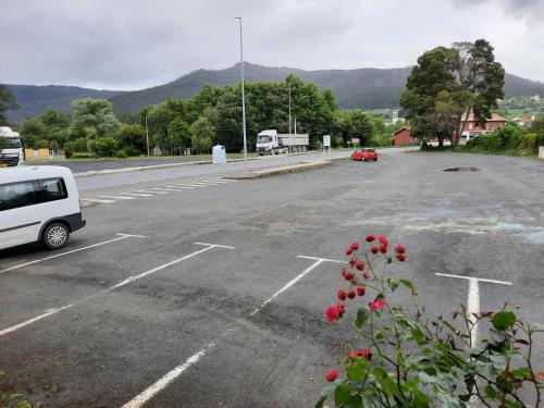 un estacionamiento vacío con una furgoneta blanca estacionada en él en Hotel Pedramea en A Coruña