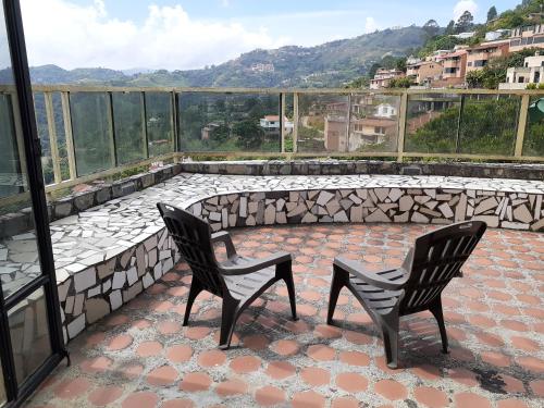 2 stoelen op een patio met uitzicht bij Aparto Suites 132, CA. in La Lagunita