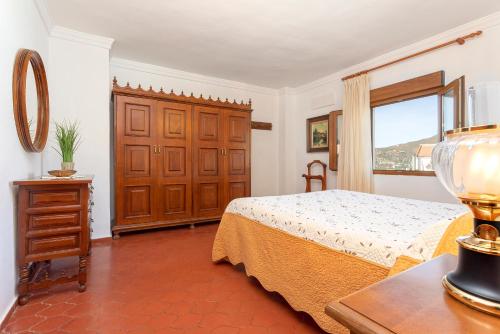 a bedroom with a bed and a window at Casa Jardín del Olivar con Piscina privada in Alcaucín