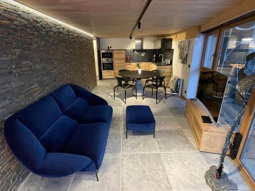 un salon avec un canapé bleu et une table dans l'établissement Loft haut de gamme avec jacuzzi, à La Bresse