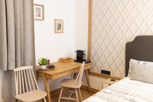 Schlafzimmer mit einem Schreibtisch mit 2 Stühlen und einem Bett in der Unterkunft Luxury rooms 12-2 in Plowdiw