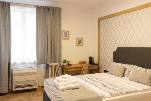 a bedroom with a bed and a desk and a window at Luxury rooms 12-2 in Plovdiv