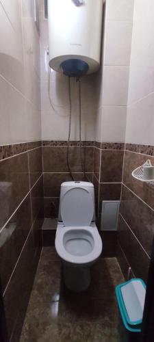 a bathroom with a toilet with a light above it at Semey in Semey