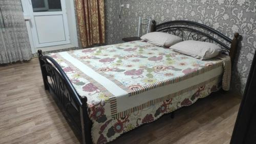 een bed met een dekbed in een slaapkamer bij Semey in Semey