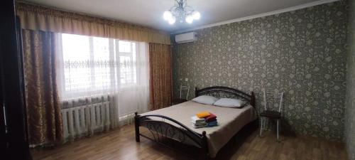 a bedroom with a bed and a large window at Semey in Semey