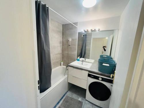 La salle de bains est pourvue d'un lavabo, d'une baignoire et d'une douche. dans l'établissement Le Nid Olympe - Metro - Wifi - Parking - Dream Host, à Saint-Denis