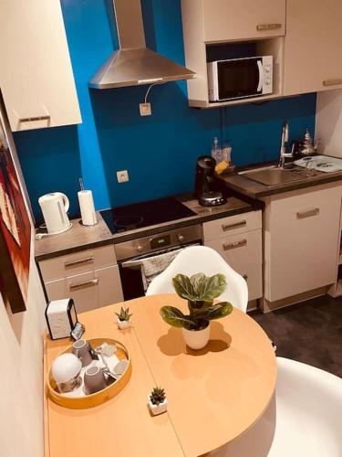 - une petite cuisine avec une table et une table dans l'établissement Logement idéal ,salle de cinéma , Jardin ,Terrasse, à Charleville-Mézières