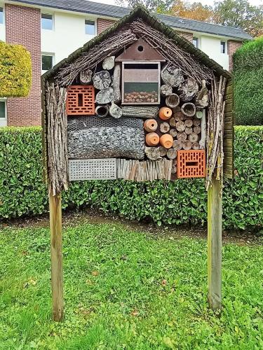 a house made out of logs in the grass at ibis les Etangs des Moines in Fourmies