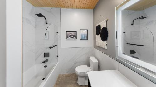 a white bathroom with a toilet and a shower at RAVN HAÜS - Oregon's Premier Alpine Retreat in Government Camp