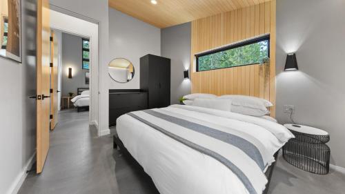 a bedroom with a large white bed and a window at RAVN HAÜS - Oregon's Premier Alpine Retreat in Government Camp