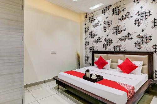 una camera da letto con un grande letto con cuscini rossi di Super OYO Flagship Hotel Sky Land a Ludhiana