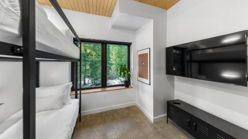 a room with a bunk bed and a large tv at RAVN HAÜS - Oregon's Premier Alpine Retreat in Government Camp
