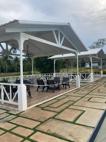 a pavilion with chairs and umbrellas on a patio at The Eliana Farm Resort and Villas in Manolo Fortich