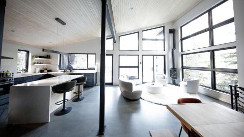 a kitchen and living room with a lot of windows at RAVN HAÜS - Oregon's Premier Alpine Retreat in Government Camp