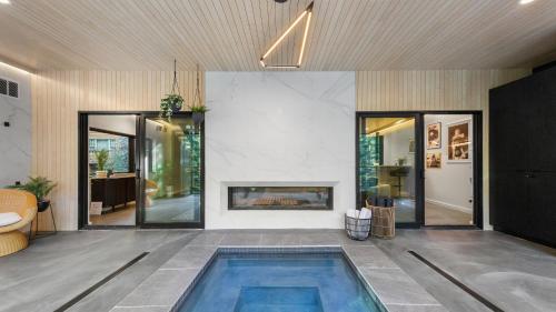 a living room with a fireplace and a swimming pool at RAVN HAÜS - Oregon's Premier Alpine Retreat in Government Camp