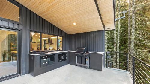 an outdoor kitchen on a house with a balcony at RAVN HAÜS - Oregon's Premier Alpine Retreat in Government Camp