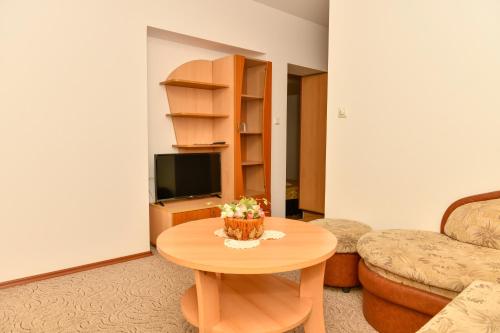 a living room with a table with flowers on it at Blyan Family Hotel in Chiflik
