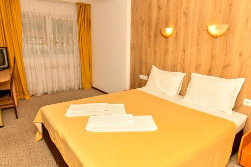 a hotel room with a bed with towels on it at Blyan Family Hotel in Chiflik