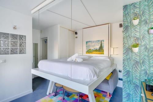 um quarto com uma cama branca e uma parede de vidro em Bright and spacious studio in Montreuil - Welkeys em Montreuil