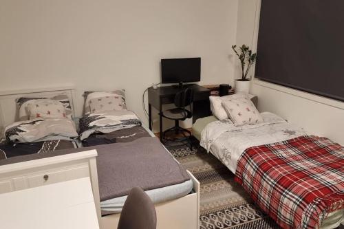 a room with two beds and a desk with a computer at Studio apartment 10mins from Oslo Cent. station. in Oslo