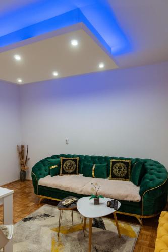 a green couch in a living room with a blue ceiling at Apartman Princip in Pale