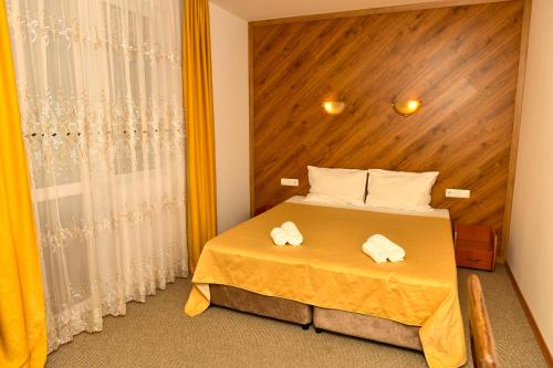 1 dormitorio con 1 cama con 2 toallas en Blyan Family Hotel, en Chiflik