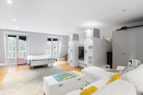 a white room with two beds and a table at Luxurious Apartment in Kensington in London